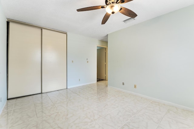 2561 Carambola Cir N Unit 1848Bldg 8, Coconut Creek, FL 33066 - unfurnished bedroom featuring a closet, a ceiling fan, and baseboards