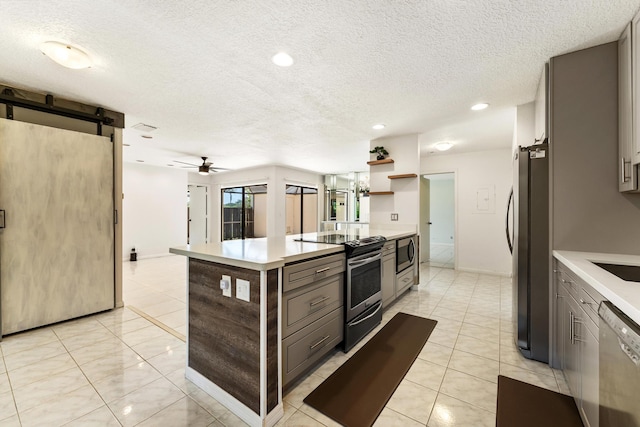 2561 Carambola Cir N Unit 1848Bldg 8, Coconut Creek, FL 33066 - kitchen with stainless steel appliances, a barn door, light countertops, gray cabinetry, and a textured ceiling
