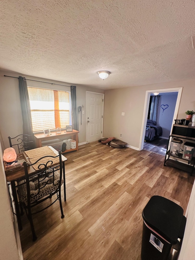 2002 N 50th St, Fort Pierce, FL 34947 - dining room featuring light wood-type flooring, a textured ceiling, and baseboards