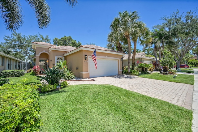 mediterranean / spanish house with stucco siding, a tile roof, an attached garage, and a front yard