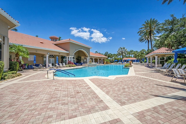 community pool with a gazebo and a patio area