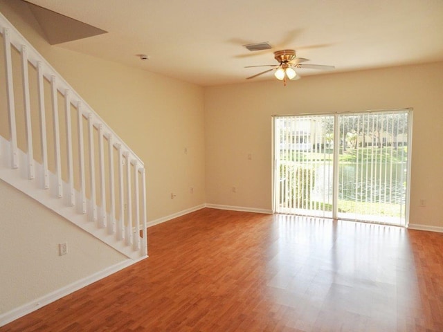 5927 Riverside Ave, Tamarac, FL 33321 - unfurnished room featuring stairs, ceiling fan, wood finished floors, and baseboards