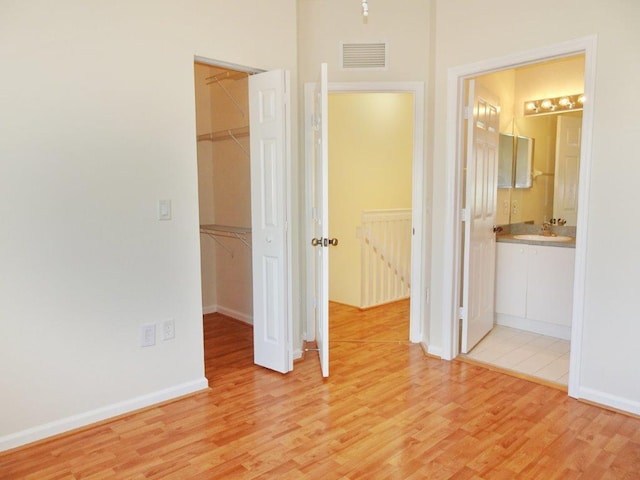 5927 Riverside Ave, Tamarac, FL 33321 - unfurnished bedroom with a walk in closet, light wood-type flooring, a closet, and baseboards
