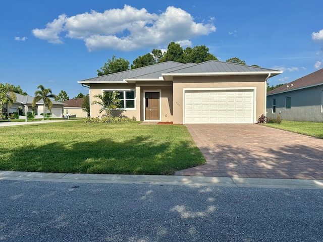 660 NE Moss Rose Pl, Port Saint Lucie, FL 34983 - view of front of house with stucco siding, a standing seam roof, a front lawn, driveway, and an attached garage