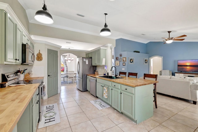 401 SE Ron Rico Ter, Port Saint Lucie, FL 34983 - kitchen featuring green cabinets, butcher block countertops, stainless steel appliances, arched walkways, and crown molding