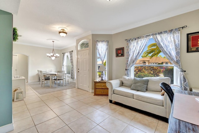 401 SE Ron Rico Ter, Port Saint Lucie, FL 34983 - living room featuring light tile patterned floors, a chandelier, ornamental molding, arched walkways, and baseboards