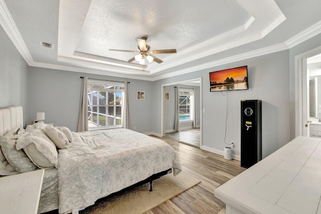 401 SE Ron Rico Ter, Port Saint Lucie, FL 34983 - bedroom with a raised ceiling, light wood-style floors, a ceiling fan, crown molding, and baseboards
