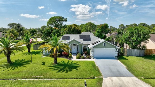 401 SE Ron Rico Ter, Port Saint Lucie, FL 34983 - view of front of house with roof mounted solar panels, an attached garage, concrete driveway, and stucco siding