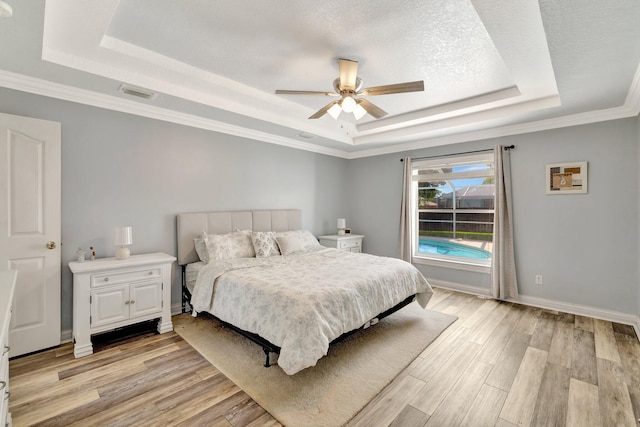 401 SE Ron Rico Ter, Port Saint Lucie, FL 34983 - bedroom with a raised ceiling, light wood-type flooring, a ceiling fan, and crown molding