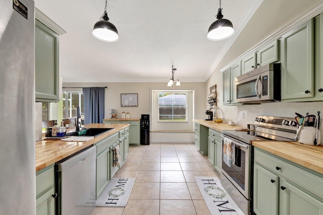 401 SE Ron Rico Ter, Port Saint Lucie, FL 34983 - kitchen with green cabinets, stainless steel appliances, wooden counters, and crown molding