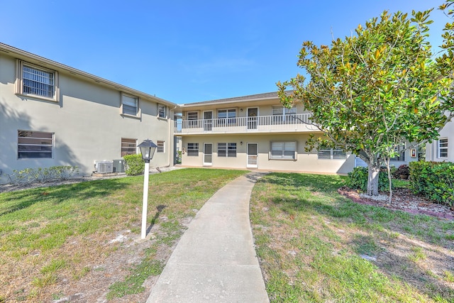 25 Lake Vista Trl Unit 203, Port Saint Lucie, FL 34952 - rear view of property featuring stucco siding, a lawn, central AC, and a balcony