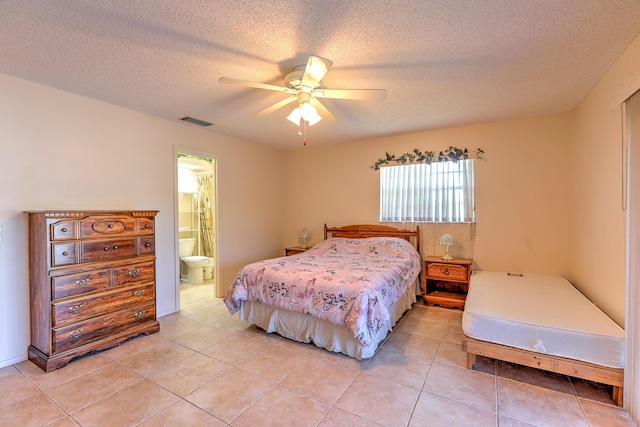 25 Lake Vista Trl Unit 203, Port Saint Lucie, FL 34952 - bedroom with light tile patterned floors, a textured ceiling, ensuite bathroom, and ceiling fan