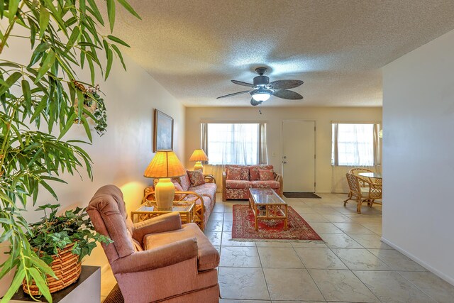 25 Lake Vista Trl Unit 203, Port Saint Lucie, FL 34952 - living area with a textured ceiling, ceiling fan, light tile patterned floors, and baseboards