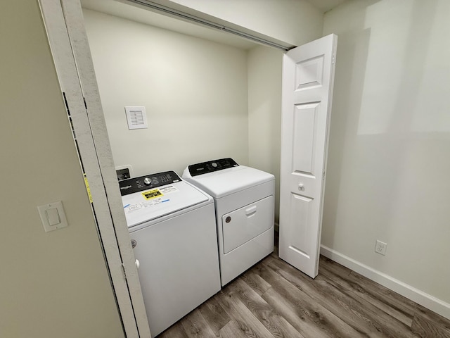 1962 SE Manth Ln, Port Saint Lucie, FL 34983 - laundry room featuring wood finished floors, washer and clothes dryer, and baseboards