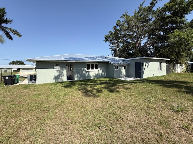 1962 SE Manth Ln, Port Saint Lucie, FL 34983 - rear view of property with central AC unit, stucco siding, and metal roof