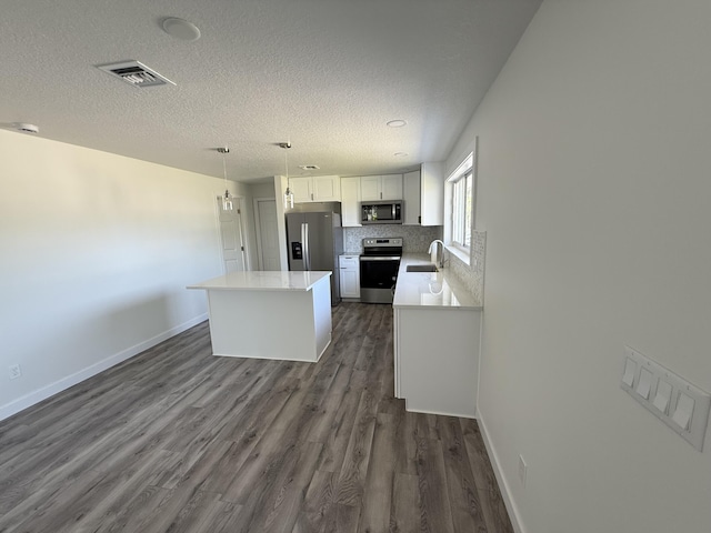 1962 SE Manth Ln, Port Saint Lucie, FL 34983 - kitchen with stainless steel appliances, a sink, dark wood-type flooring, light countertops, and a center island