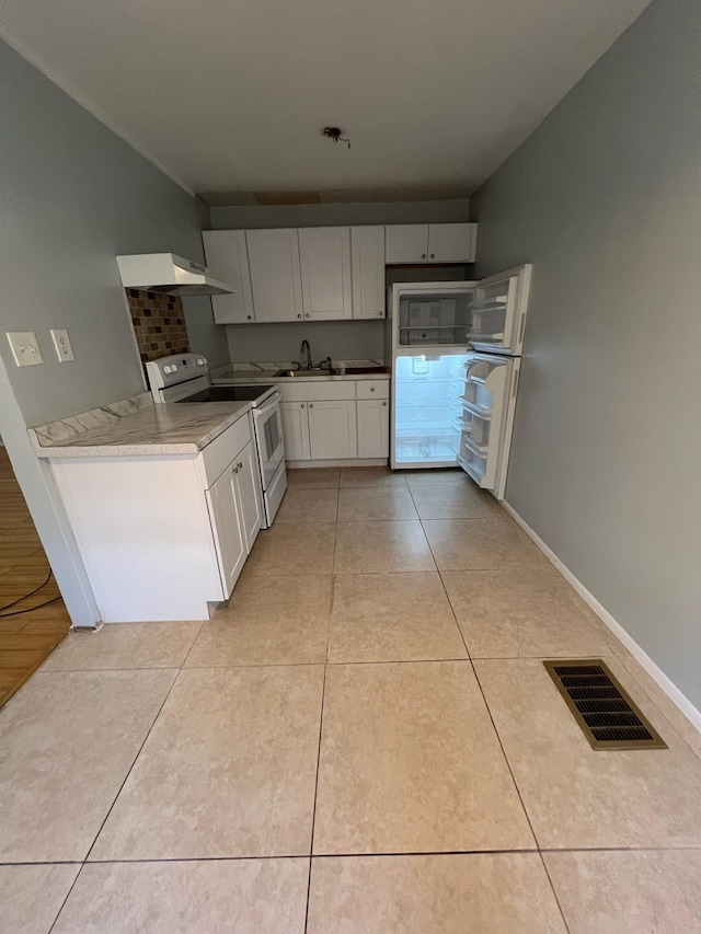 702 48th St, West Palm Beach, FL 33407 - kitchen featuring white range with electric stovetop, a sink, light tile patterned floors, white cabinetry, and baseboards