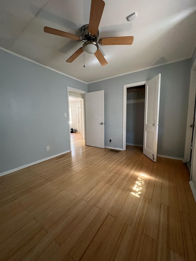 702 48th St, West Palm Beach, FL 33407 - unfurnished bedroom with wood finished floors, crown molding, a closet, baseboards, and a ceiling fan