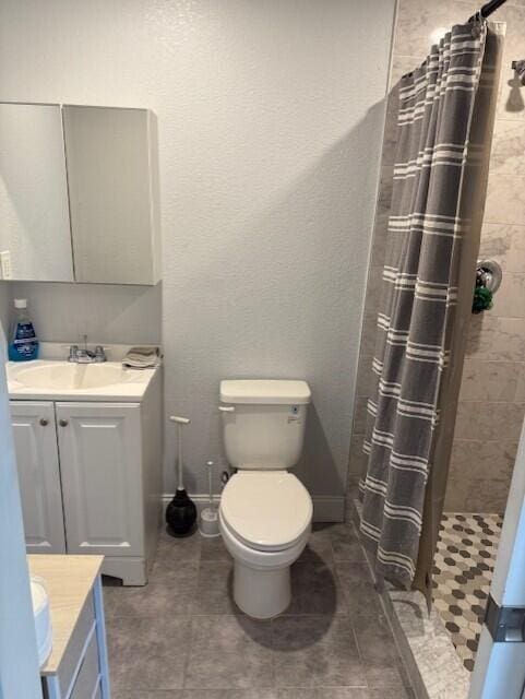 full bathroom with vanity, a shower stall, toilet, tile patterned flooring, and baseboards