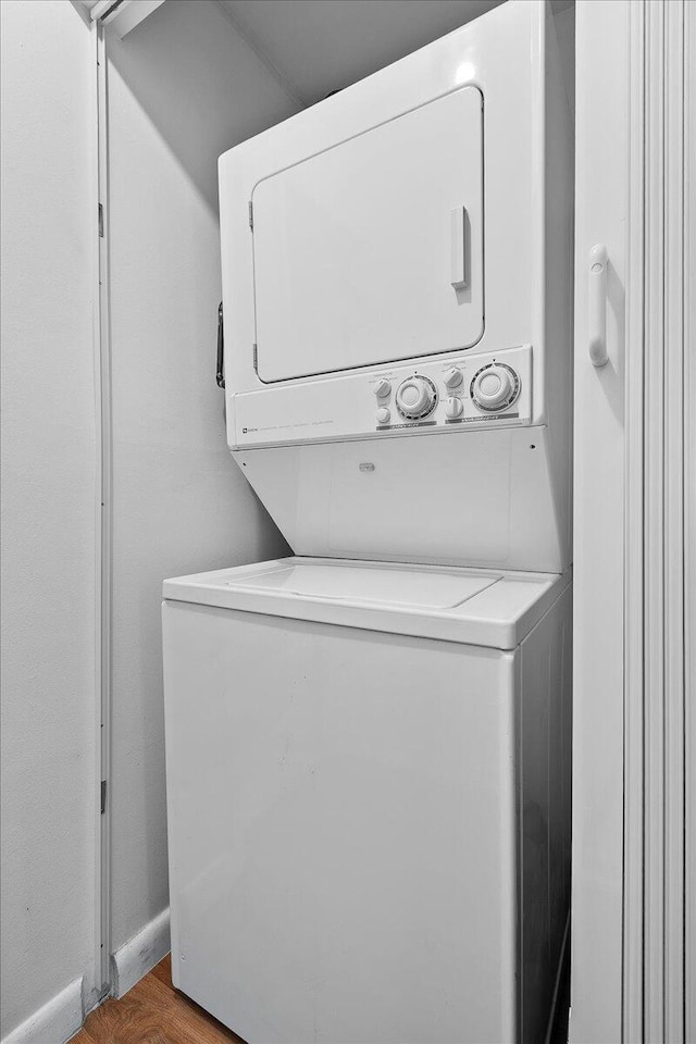 884 Worcester Ln, Lake Worth, FL 33467 - washroom featuring stacked washing machine and dryer and wood finished floors