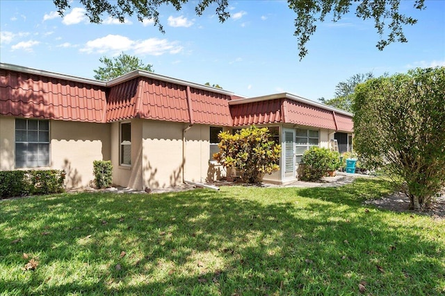 884 Worcester Ln, Lake Worth, FL 33467 - view of front of home featuring mansard roof, a front yard, and stucco siding