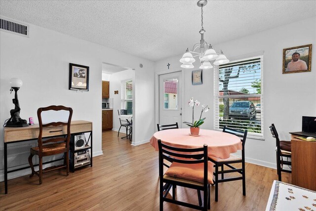 884 Worcester Ln, Lake Worth, FL 33467 - dining area featuring a chandelier, a textured ceiling, light wood finished floors, and baseboards