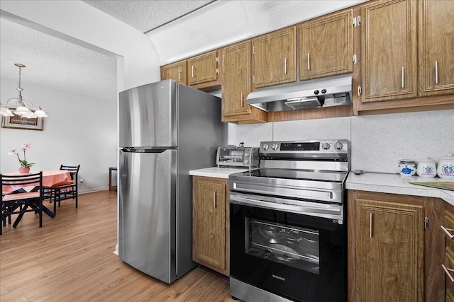 884 Worcester Ln, Lake Worth, FL 33467 - kitchen featuring appliances with stainless steel finishes, under cabinet range hood, brown cabinets, light countertops, and a textured ceiling