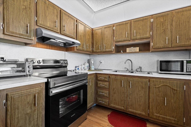 884 Worcester Ln, Lake Worth, FL 33467 - kitchen with under cabinet range hood, stainless steel appliances, a sink, and light countertops