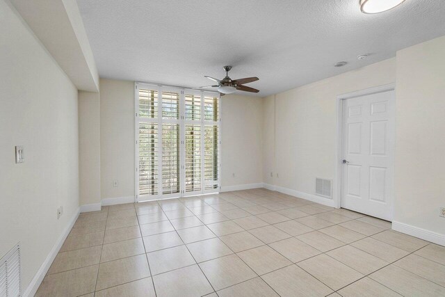 610 Clematis St Unit 236, West Palm Beach, FL 33401 - empty room featuring a ceiling fan, a textured ceiling, light tile patterned flooring, and baseboards