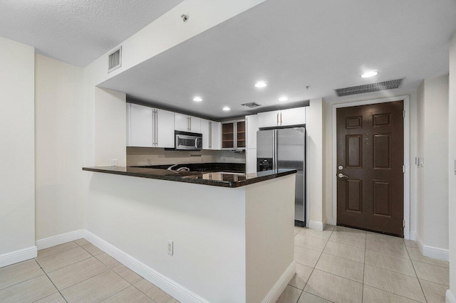 610 Clematis St Unit 236, West Palm Beach, FL 33401 - kitchen with appliances with stainless steel finishes, light tile patterned floors, a peninsula, white cabinets, and recessed lighting