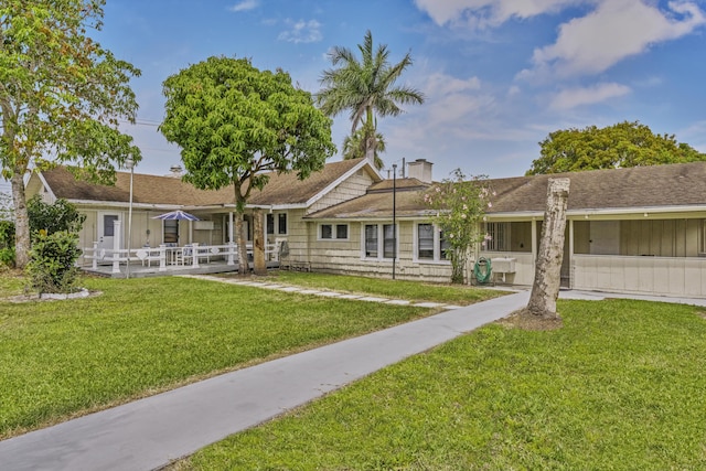 14601 Orange Ave, Fort Pierce, FL 34945 - back of property featuring a yard, a chimney, and roof with shingles
