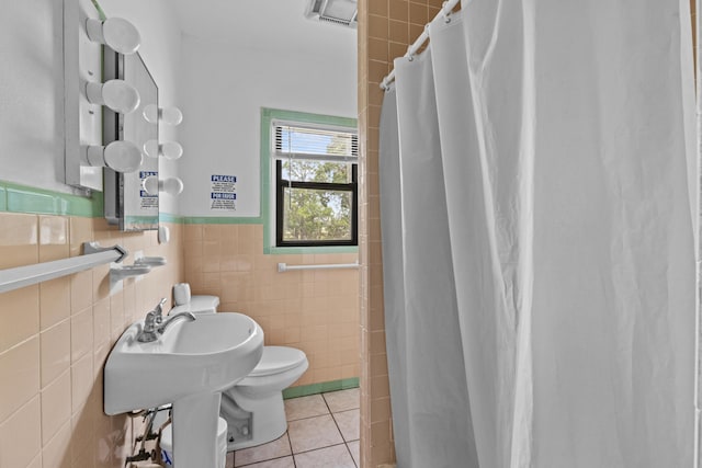 14601 Orange Ave, Fort Pierce, FL 34945 - bathroom featuring tile walls, toilet, tile patterned floors, a shower with curtain, and a wainscoted wall