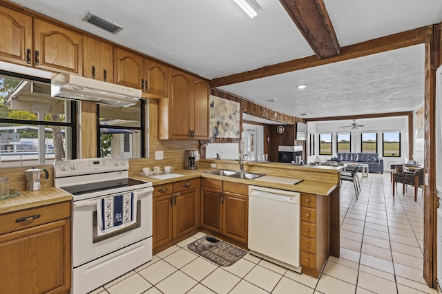 14601 Orange Ave, Fort Pierce, FL 34945 - kitchen featuring white appliances, a sink, a peninsula, light countertops, and beam ceiling