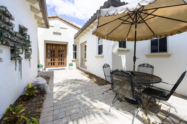 1081 Vintner Blvd, Palm Beach Gardens, FL 33410 - view of patio with french doors and outdoor dining area