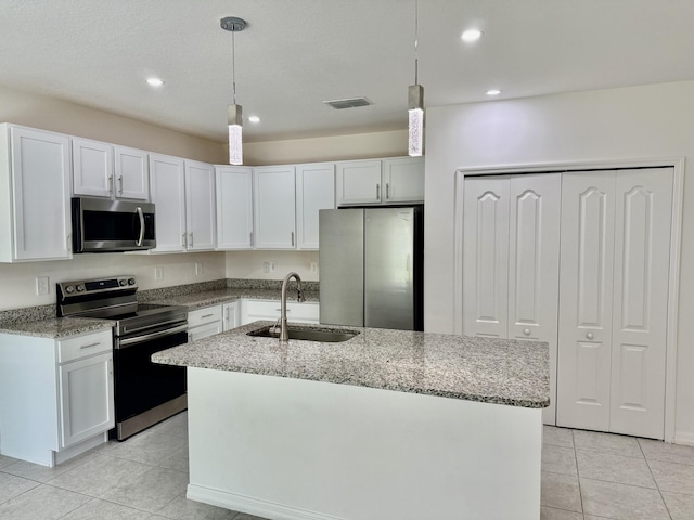 763 SE Evergreen Ter, Port Saint Lucie, FL 34983 - kitchen with appliances with stainless steel finishes, a sink, light tile patterned floors, light stone counters, and an island with sink