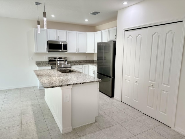 763 SE Evergreen Ter, Port Saint Lucie, FL 34983 - kitchen with stainless steel appliances, a sink, light stone countertops, an island with sink, and recessed lighting