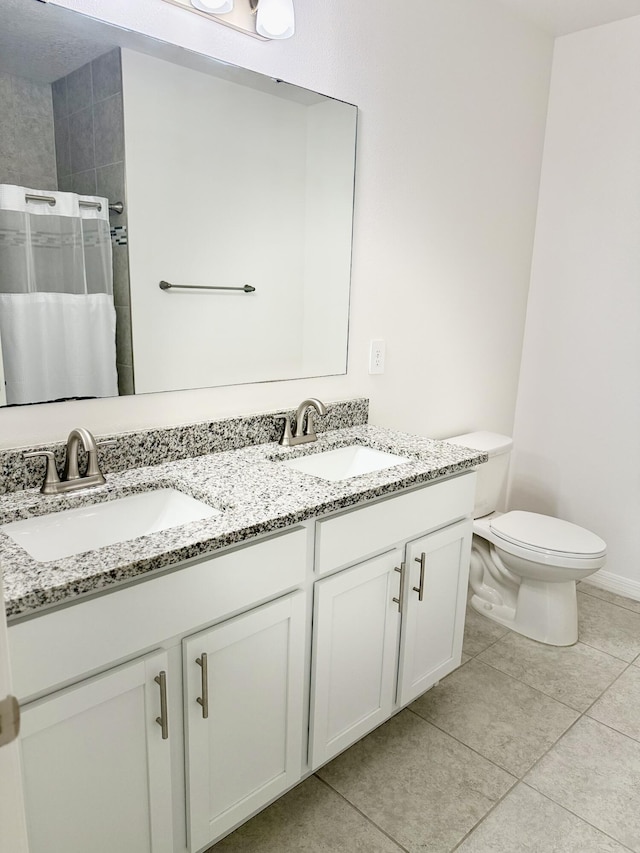 763 SE Evergreen Ter, Port Saint Lucie, FL 34983 - full bathroom with a tile shower, toilet, double vanity, tile patterned floors, and baseboards
