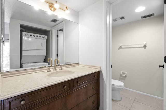 1631 SE Green Acres Cir Unit Bb103, Port Saint Lucie, FL 34952 - bathroom featuring stacked washing machine and dryer, tile patterned flooring, toilet, vanity, and baseboards