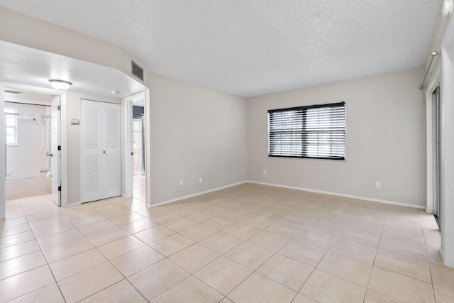 1631 SE Green Acres Cir Unit Bb103, Port Saint Lucie, FL 34952 - unfurnished room featuring light tile patterned flooring, a textured ceiling, and baseboards