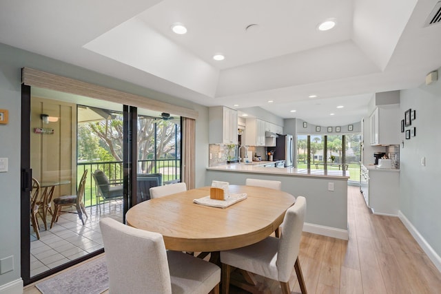17166 Waterbend Dr Unit 210, Jupiter, FL 33477 - dining room featuring a tray ceiling, light wood-style floors, baseboards, and recessed lighting