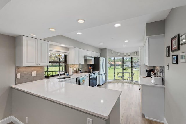17166 Waterbend Dr Unit 210, Jupiter, FL 33477 - kitchen featuring appliances with stainless steel finishes, light countertops, a sink, backsplash, and white cabinetry