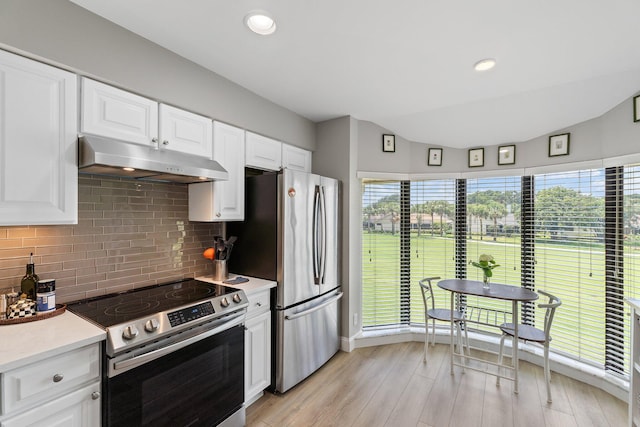 17166 Waterbend Dr Unit 210, Jupiter, FL 33477 - kitchen with appliances with stainless steel finishes, under cabinet range hood, light countertops, tasteful backsplash, and white cabinets