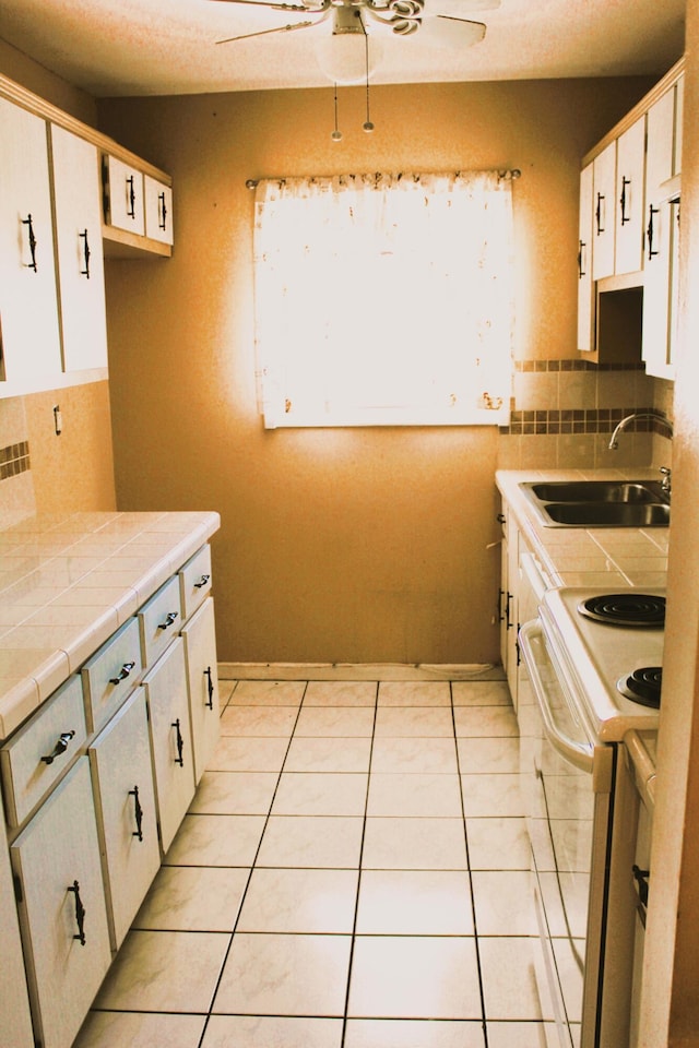 540 High Point Dr Unit A, Delray Beach, FL 33445 - kitchen with electric range, a sink, a ceiling fan, decorative backsplash, and light tile patterned floors