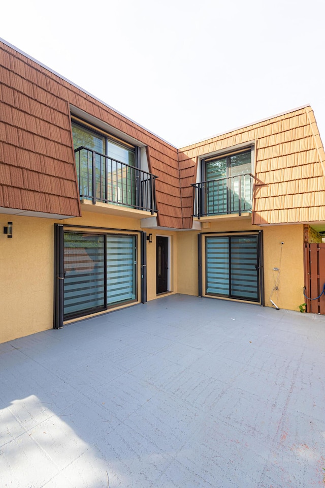 1515 Augusta Cir Unit 116, Delray Beach, FL 33445 - view of front of property featuring mansard roof, stucco siding, and a balcony