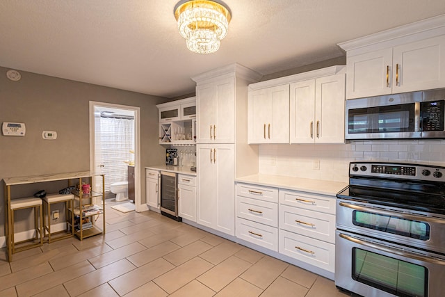 1515 Augusta Cir Unit 116, Delray Beach, FL 33445 - kitchen with stainless steel appliances, wine cooler, decorative backsplash, light countertops, and a textured ceiling