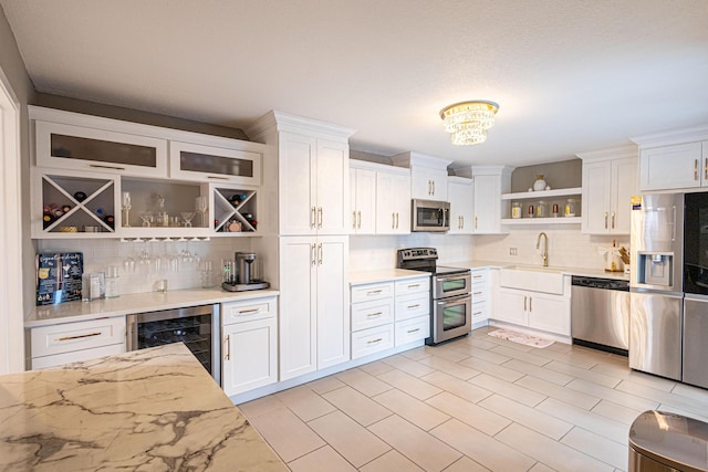 1515 Augusta Cir Unit 116, Delray Beach, FL 33445 - kitchen featuring appliances with stainless steel finishes, open shelves, wine cooler, a sink, and tasteful backsplash