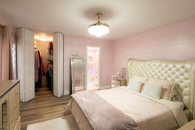 1515 Augusta Cir Unit 116, Delray Beach, FL 33445 - bedroom with a spacious closet, light wood finished floors, a closet, baseboards, and ensuite bath