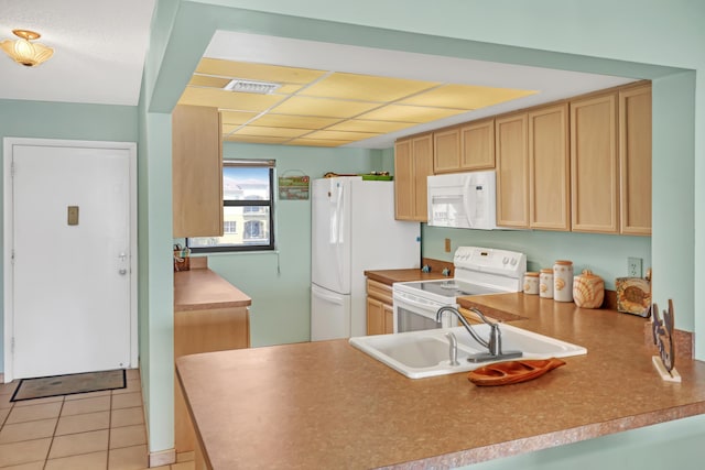 7430 S Ocean Dr Unit 319, Jensen Beach, FL 34957 - kitchen featuring white appliances, a sink, a peninsula, light brown cabinetry, and light tile patterned floors