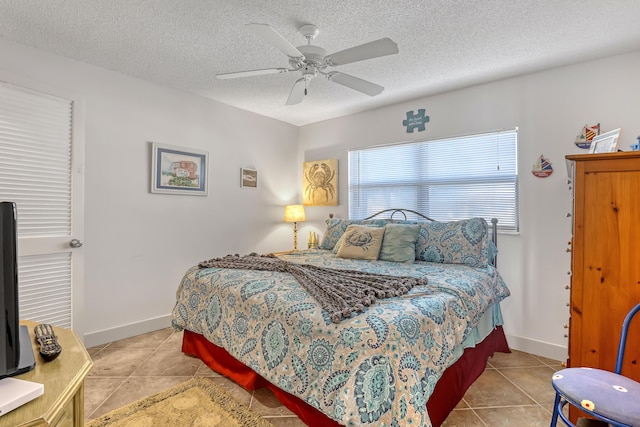 7430 S Ocean Dr Unit 319, Jensen Beach, FL 34957 - bedroom with tile patterned flooring, a textured ceiling, a ceiling fan, and baseboards