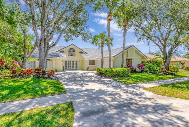 120 Bayberry Cir, Jupiter, FL 33458 - view of front of home featuring concrete driveway, french doors, and a front yard